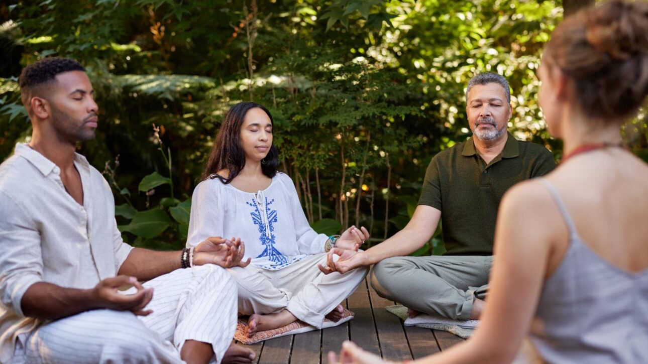 People practicing seated meditation during a yoga session in nature, Living Church Serving Richmond.
