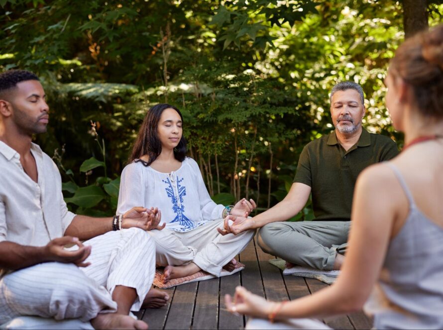 People practicing seated meditation during a yoga session in nature, Living Church Serving Richmond.