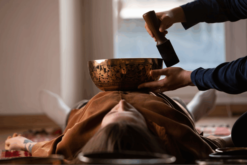 A bowl used during sound bath treatments sitting on a woman’s chest.