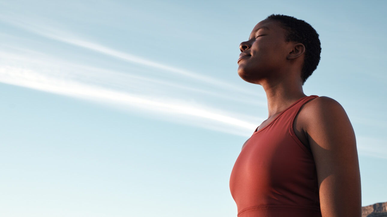 A woman pauses on a high rise to practice her breathwork.