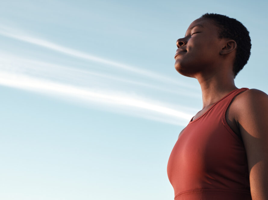 A woman pauses on a high rise to practice her breathwork.