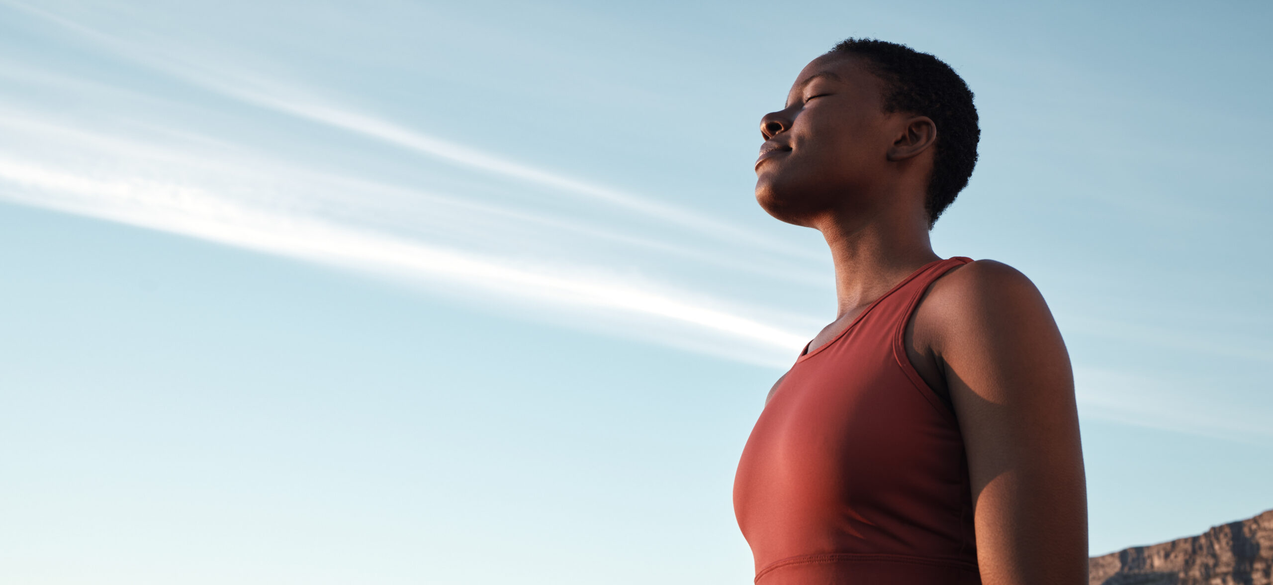 A woman pauses on a high rise to practice her breathwork.