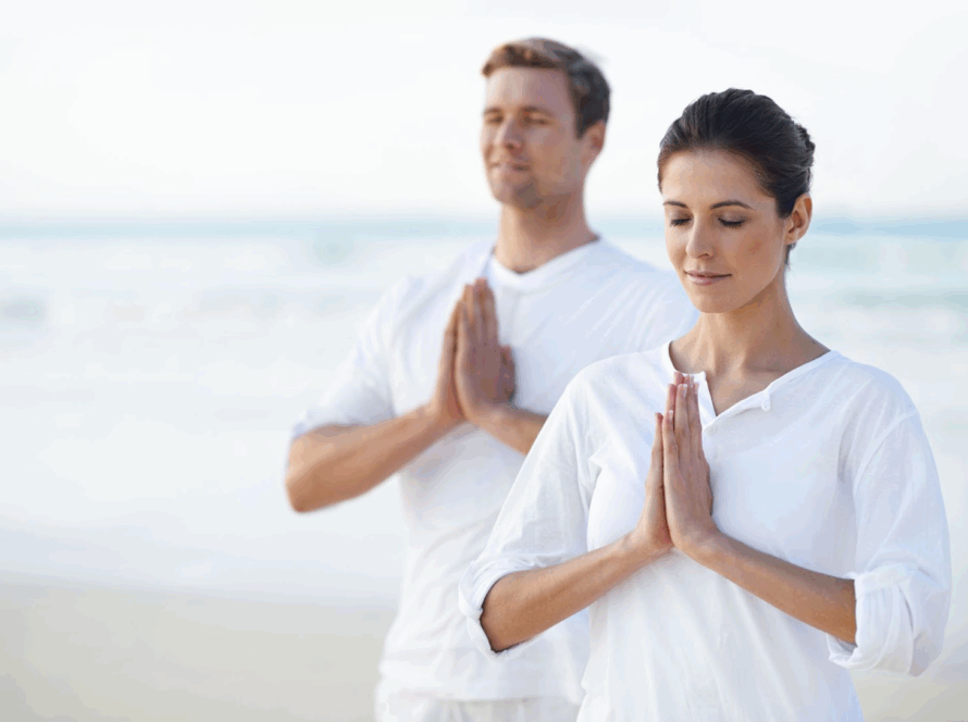 Two people meditating by the sea.