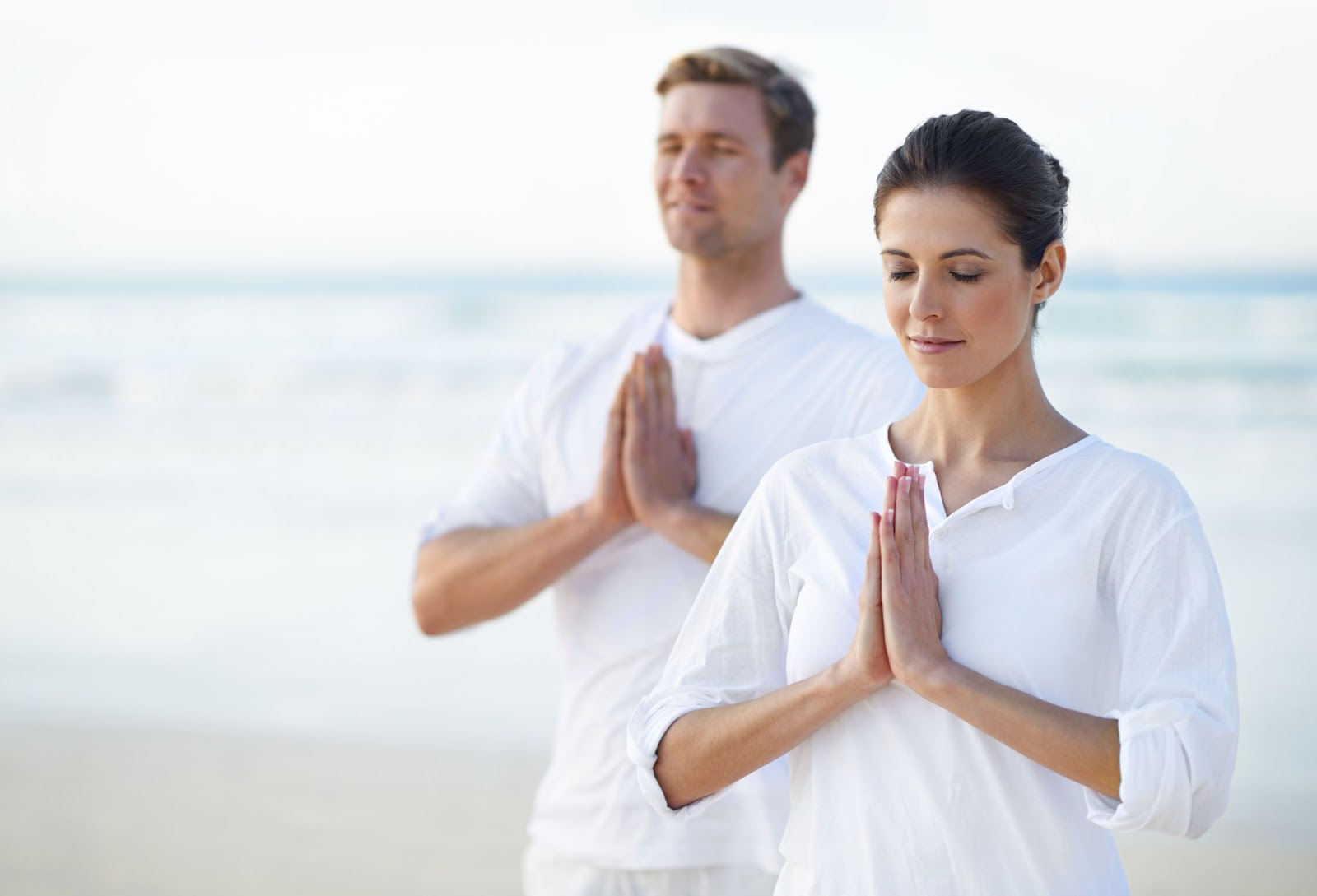 Two people meditating by the sea.