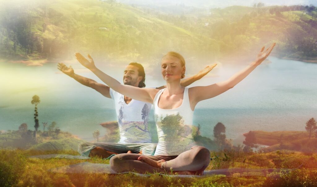 Couple practicing yoga in nature with arms raised, nurturing spiritual health and emotional well-being.