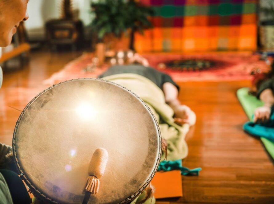 Two people lying down during a sound bath given by an instructor.