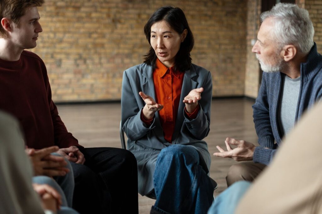 An Asian female leader calmly speaking with her business team during a professional discussion.