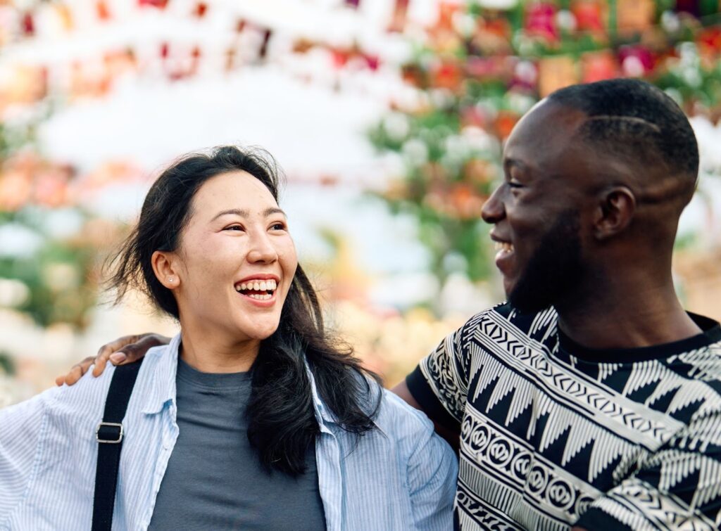 Young and happy interracial couple enjoying time together in a park.