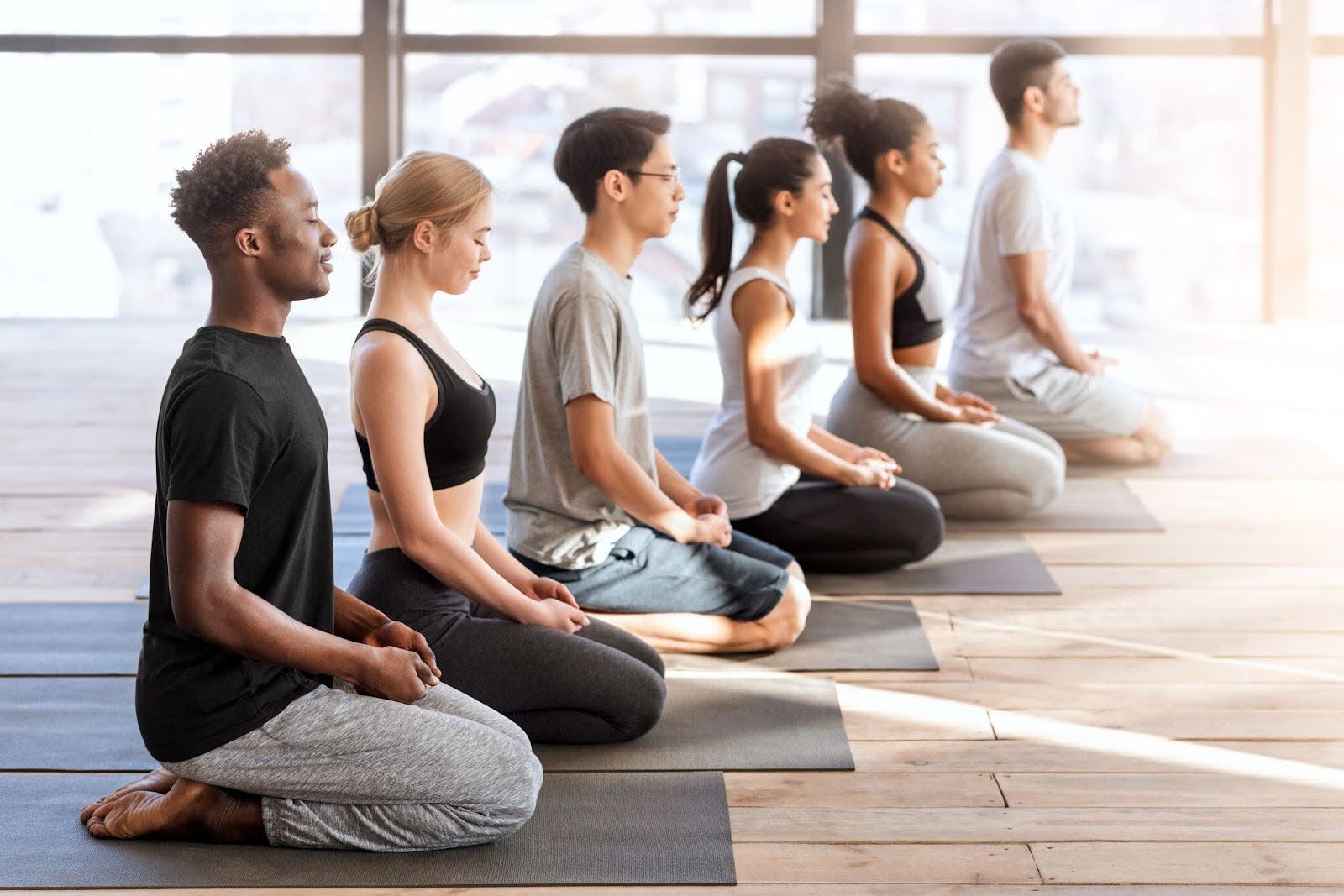Diverse young adults participating in a beginner meditation exercise focused on breathing and relaxation.
