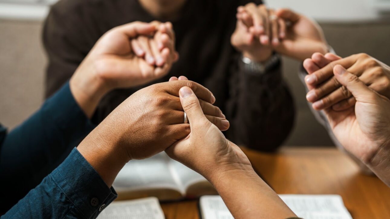 A diverse group of young believers praying as a community for faith, unity, and God’s blessings