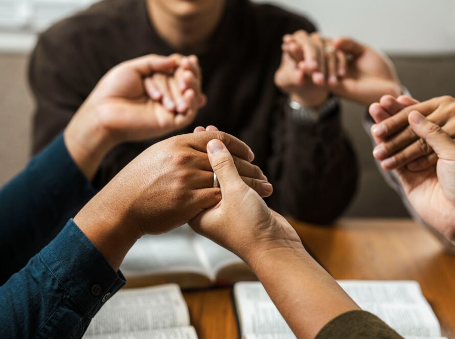A diverse group of young believers praying as a community for faith, unity, and God’s blessings