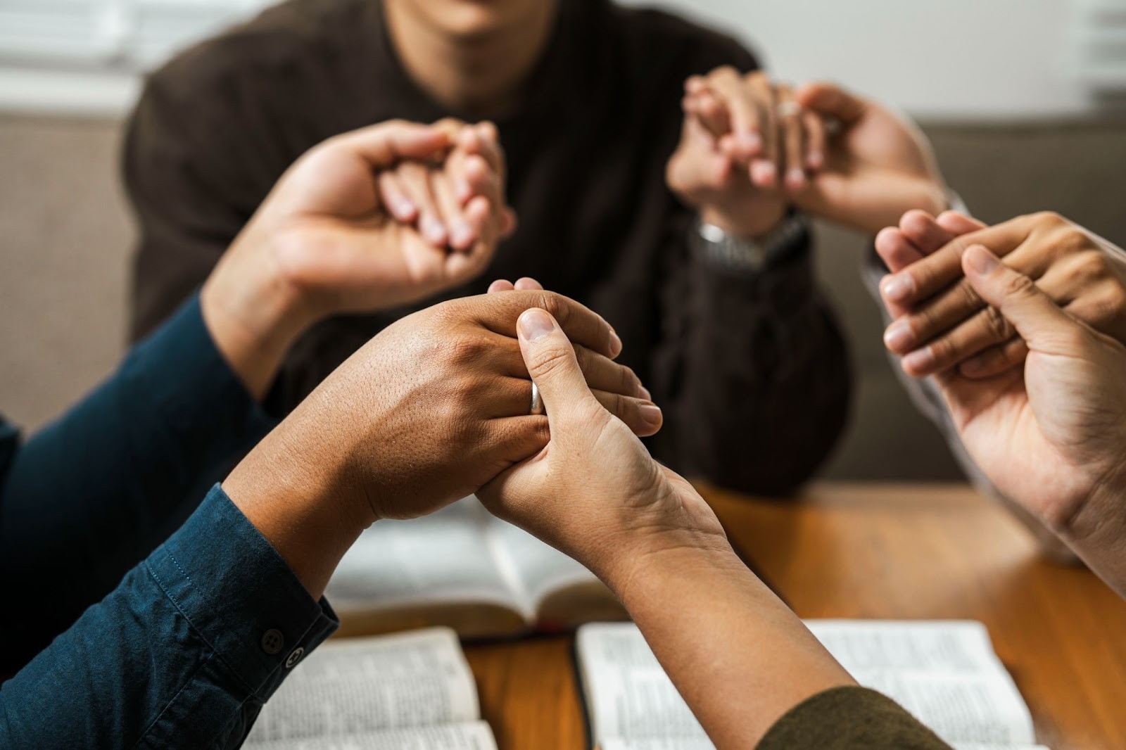 A diverse group of young believers praying as a community for faith, unity, and God’s blessings
