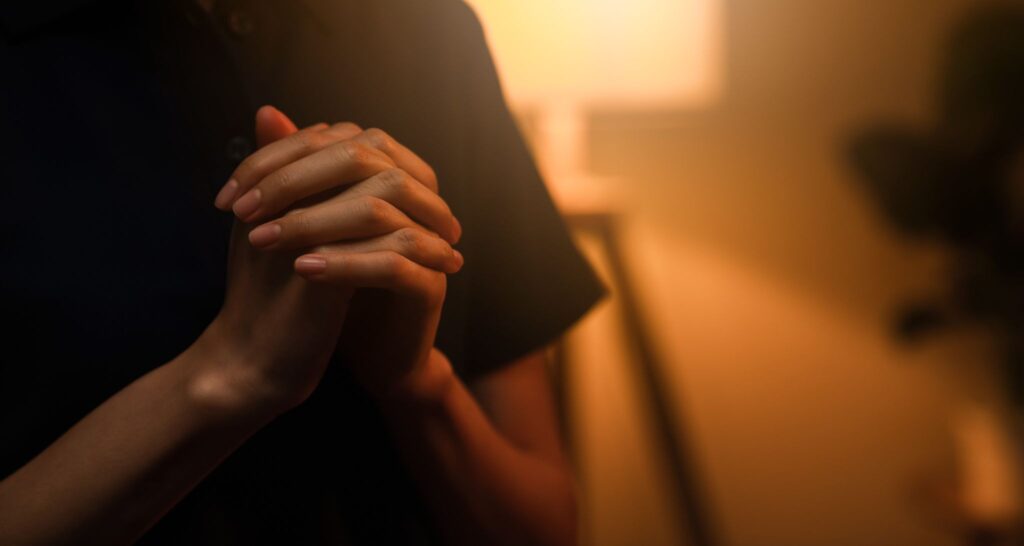 Woman with hands folded in prayer. 