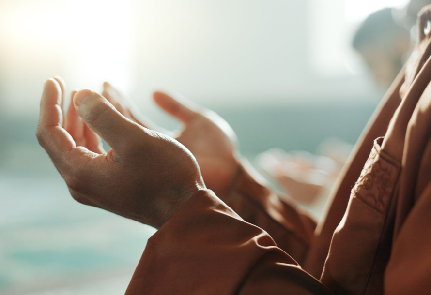 Person with hands outstretched in prayer.