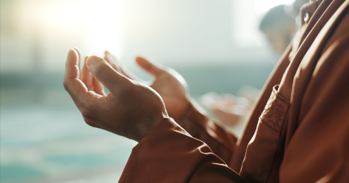 Person with hands outstretched in prayer.